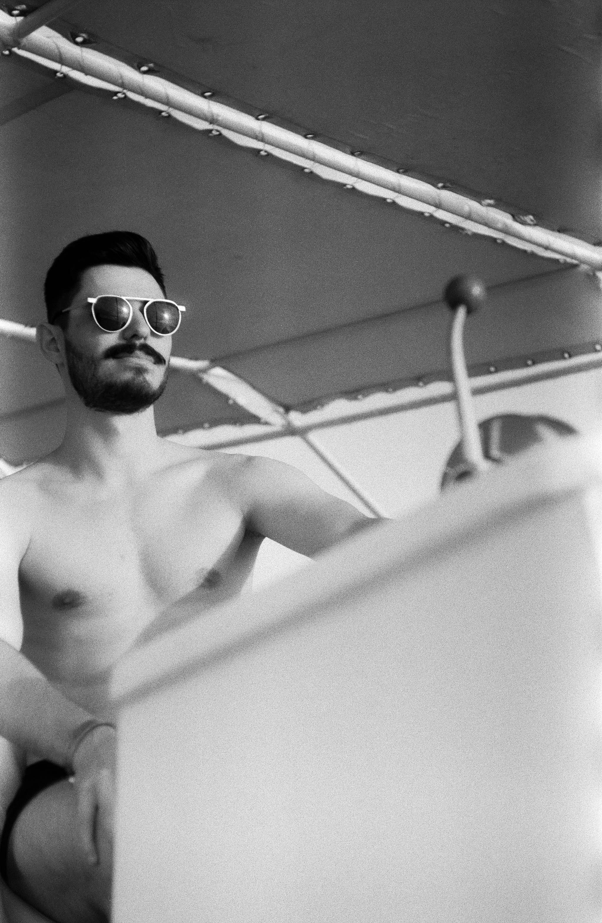 topless man wearing black sunglasses in bathtub